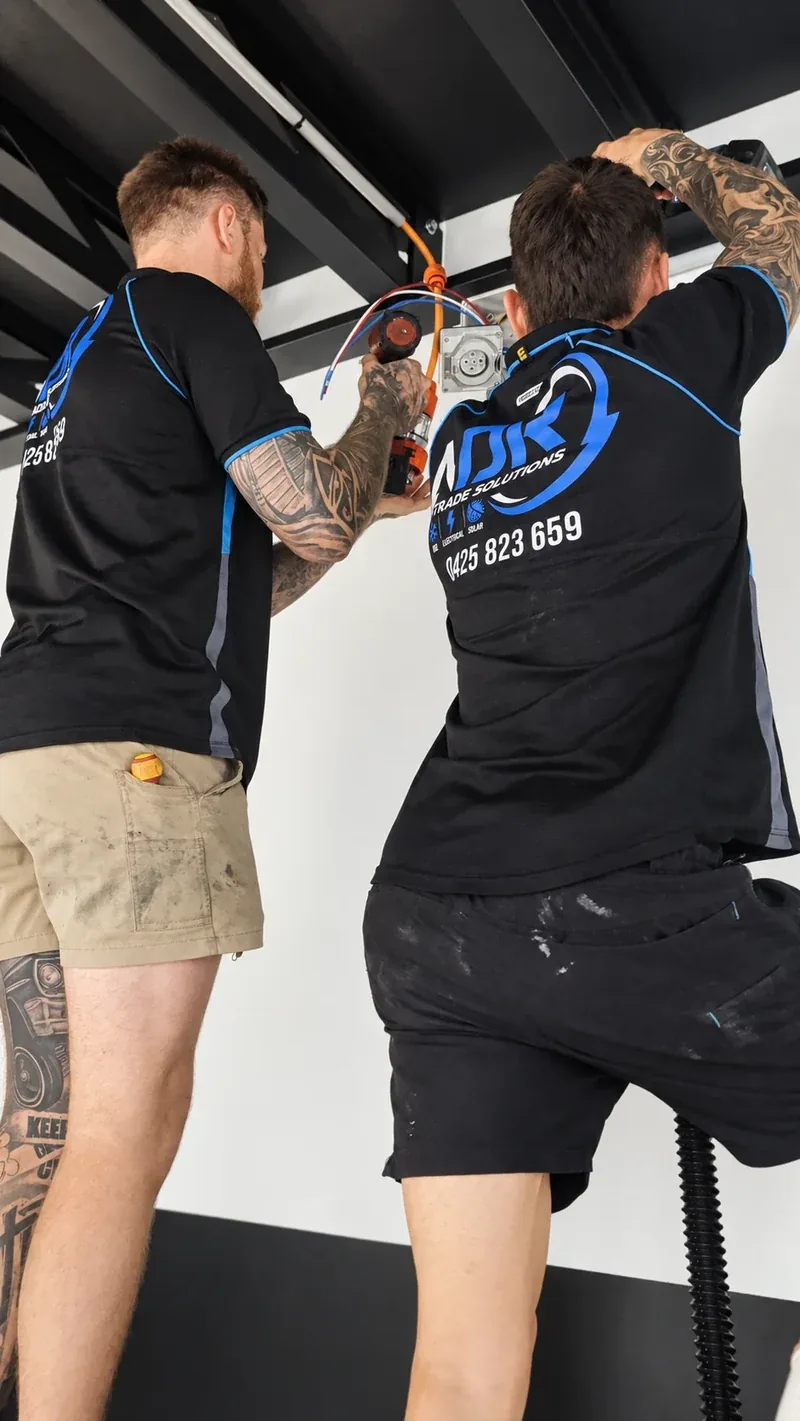 Two NDR electricians working together on an electrical installation